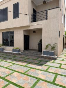 a house with a courtyard in front of it at F&F Villa in Tema
