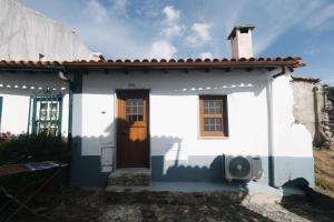 a small white house with a brown door at Casa do Javali 3 in Bragança +3 photos
