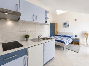 a kitchen with a sink and a bed in a room at Apartments Marija Magdalena in Hvar