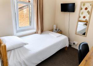 ein kleines Schlafzimmer mit einem Bett und einem Fenster in der Unterkunft Dolphins Hotel in Bournemouth