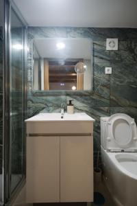 a bathroom with a sink and a toilet and a mirror at Casa do Javali 3 in Bragança