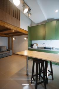 a kitchen with green cabinets and a wooden table at Casa do Javali 3 in Bragança
