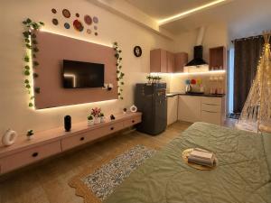 a living room with a television and a kitchen at The cozy cave in Jaipur