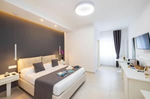 a bedroom with a large white bed and a television at Le Stagioni Rooms in Vieste