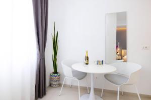 a white dining room with a white table and chairs at Le Stagioni Rooms in Vieste +27 photos