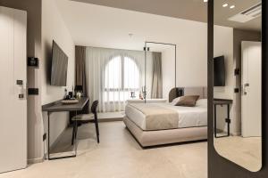 a bedroom with a bed and a desk and a table at Dimora degli archi in Terrasini