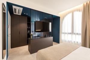 a bedroom with a flat screen tv on a wall at Dimora degli archi in Terrasini