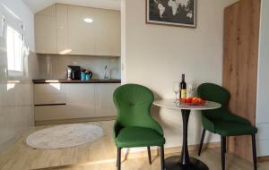 a kitchen with a table and two green chairs at The Best Lake View Studios Borisic in Vranjina +20 photos