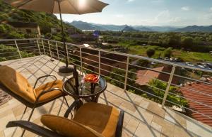 a balcony with a table and chairs and an umbrella at The Best Lake View Studios Borisic in Vranjina