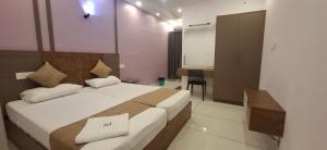 a hotel room with a bed and a desk at Aashi's Inn in Alleppey
