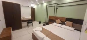 a bedroom with a bed and a desk in it at Aashi's Inn in Alleppey