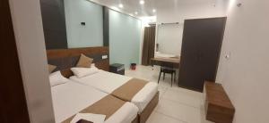 a bedroom with a bed and a desk in it at Aashi's Inn in Alleppey +4 photos