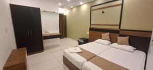 a bedroom with a large bed and a bathroom at Aashi's Inn in Alleppey