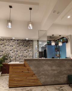 a lobby with a reception desk and a stone wall at Hotel Samrat - A Boutique Hotel in Prayagraj