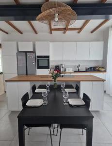 a kitchen with a black table with chairs and a counter at Suite privée charentaise in Romegoux