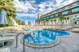 a hotel swimming pool with chairs and umbrellas at Hotel Montecito in Sofia