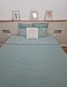 a bedroom with a bed with blue sheets and pillows at Suite privée charentaise in Romegoux