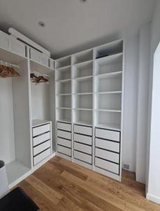 a white walk in closet with white shelves at Suite privée charentaise in Romegoux +3 photos