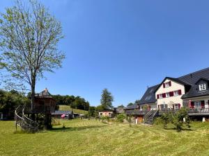 a group of houses in a field with a tree at Luxus Kutsche in Grafengehaig