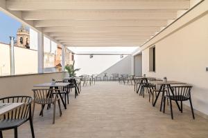 a room with tables and chairs and a building at Dimora degli archi in Terrasini