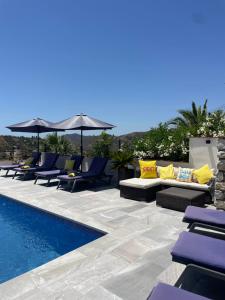 a patio with lounge chairs and a swimming pool at Bella Boutique Apartments in Cómpeta