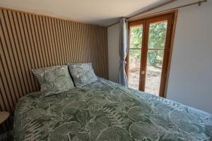 une chambre avec un lit et une fenêtre dans l'établissement cabane des vignes, à Cotignac
