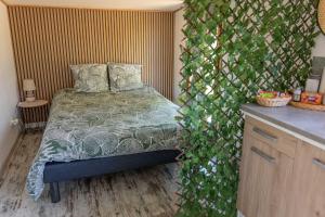 une chambre avec un lit et un mur recouvert de lierre vert dans l'établissement cabane des vignes, à Cotignac 12 autres photos