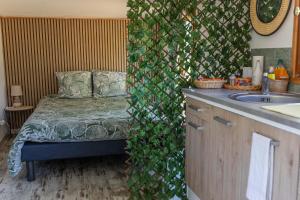 une salle de bain avec un mur recouvert de lierre et un lavabo dans l'établissement cabane des vignes, à Cotignac
