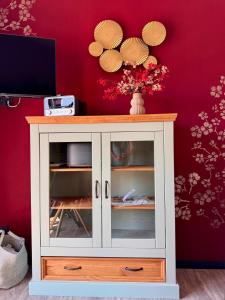 a white cabinet in a room with a red wall at Luxus Kutsche in Grafengehaig