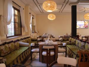 a restaurant with tables and chairs and chandeliers at Riad Perlamazigh in Zagora