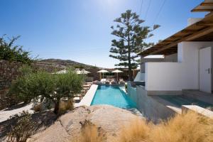 a swimming pool in front of a house at Oliving Mykonos Luxury Suites in Klouvas