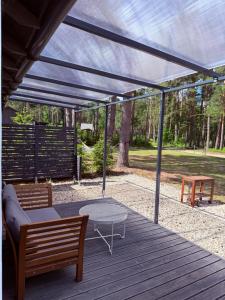 a pergola with a table and benches on a deck at Pussala Latgalē in Ezerukiņi +55 photos
