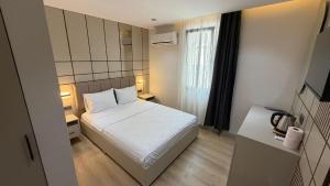 a small bedroom with a white bed and a window at Nergiz Boutique Hotel in Antalya
