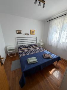 a bedroom with a bed with two towels on it at Apartments Crnko, 50m from the beach with free parking and drinkable tap water in Vir