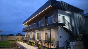 a man standing in front of a house with a staircase at Elida Guest Rooms in Cholpon-Ata