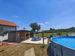 a backyard with a swimming pool and a gazebo at Kuća za odmor Bella in Sotin