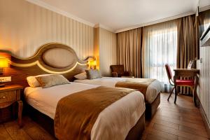 a hotel room with two beds and a desk at The central hotel in Istanbul