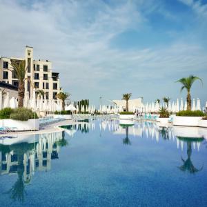 a swimming pool in a resort with palm trees and buildings at FS The Grand Sea Breeze in Baku