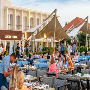 a group of people sitting at tables at a restaurant at FS The Grand Sea Breeze in Baku