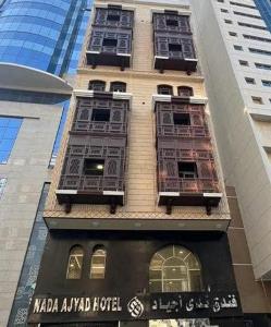 a tall building with windows and a sign on it at فندق ندى أجياد in Ajyad