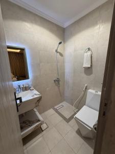 a bathroom with a toilet and a sink and a shower at فندق ندى أجياد in Ajyad