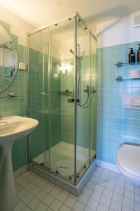 a bathroom with a glass shower and a sink at Double Room by Interlaken. Parking in Därligen