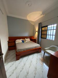 a bedroom with a bed and a chair in it at Le cozy in Abomey-Calavi