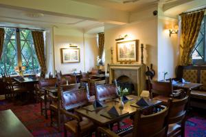 a dining room with tables and chairs and a fireplace at Stow Lodge Hotel in Stow on the Wold