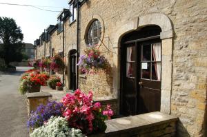 a brick building with flowers in front of a door at Stow Lodge Hotel in Stow on the Wold
