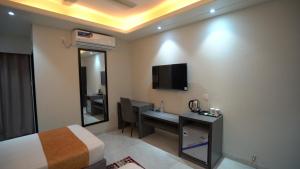 a hotel room with a bed and a desk and a television at The Swiss Hotel & Resort in Cox's Bazar