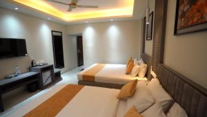 a hotel room with two beds and a television at The Swiss Hotel & Resort in Cox's Bazar