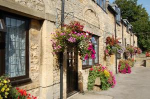 a building with flowers on the side of it at Stow Lodge Hotel in Stow on the Wold