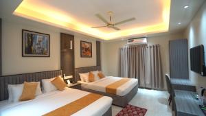 a hotel room with two beds and a television at The Swiss Hotel & Resort in Cox's Bazar +21 photos