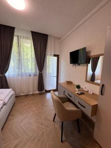 a hotel room with a bed and a desk and a television at Комплекс Ванката in Kamena